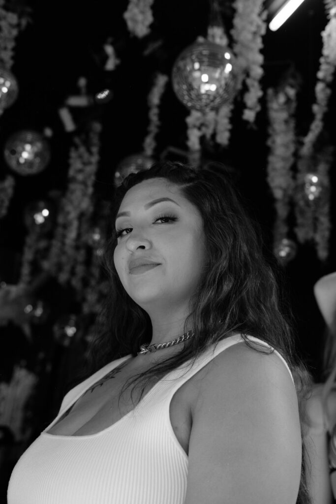 black and white with florals in the background with joyce, latina web designer looking down at camera