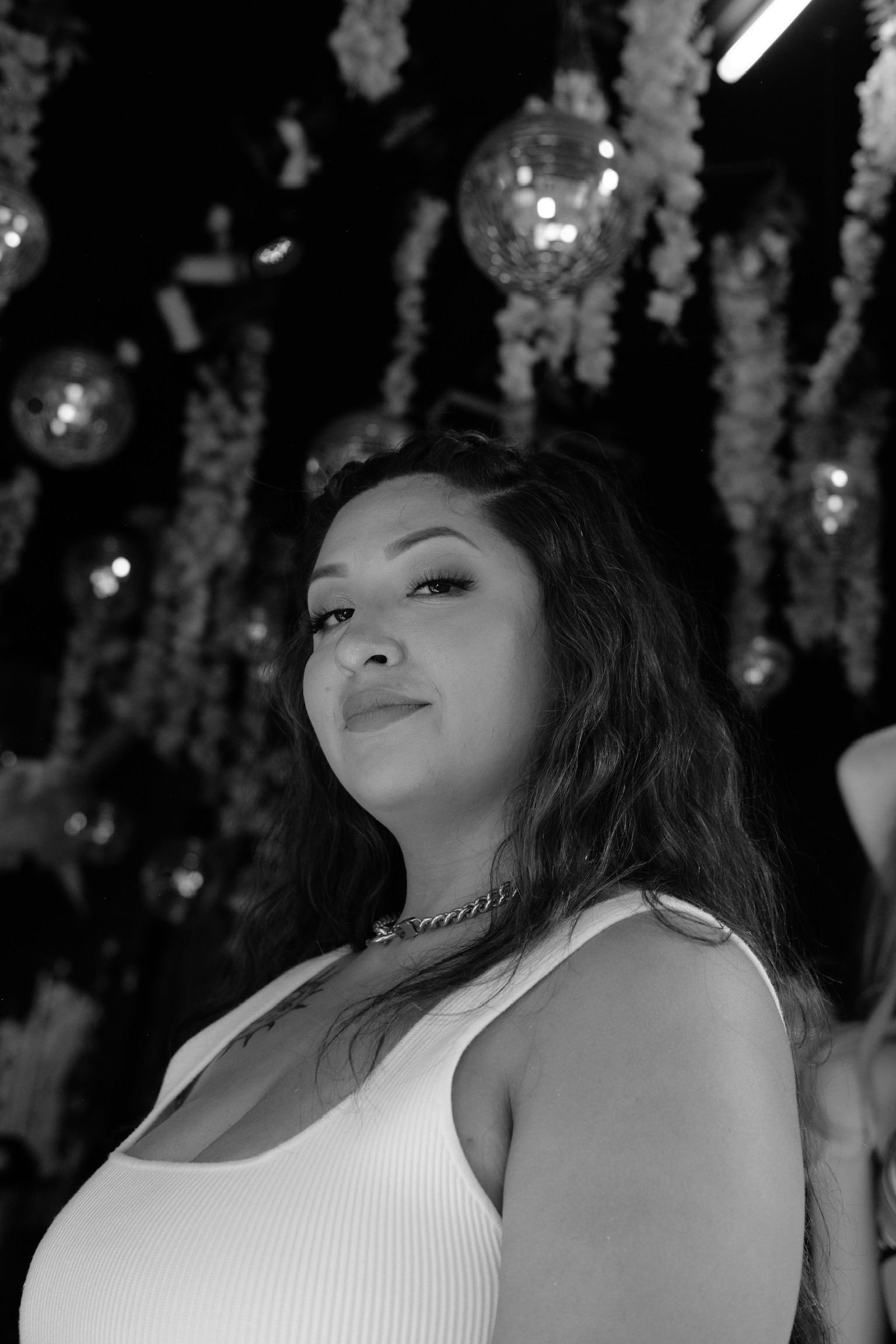 black and white with florals in the background with joyce, latina web designer looking down at camera